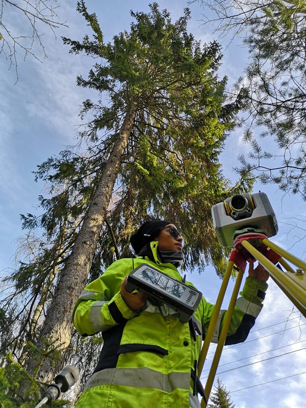 Bridget Coulter i skog med mätinstrument från Trimble